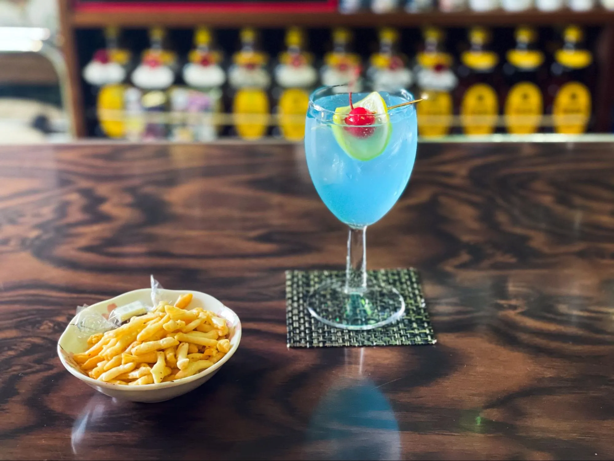 「洋酒喫茶 プリンス」の、ウミネコの繁殖地として知られる国の天然記念物「蕪島」のカクテル。ジンベースにブルーキュラソーで海を表現し、蕪島に咲く黄色い“カブの花”をカットレモンで、“鳥居”をチェリーで演出しています。