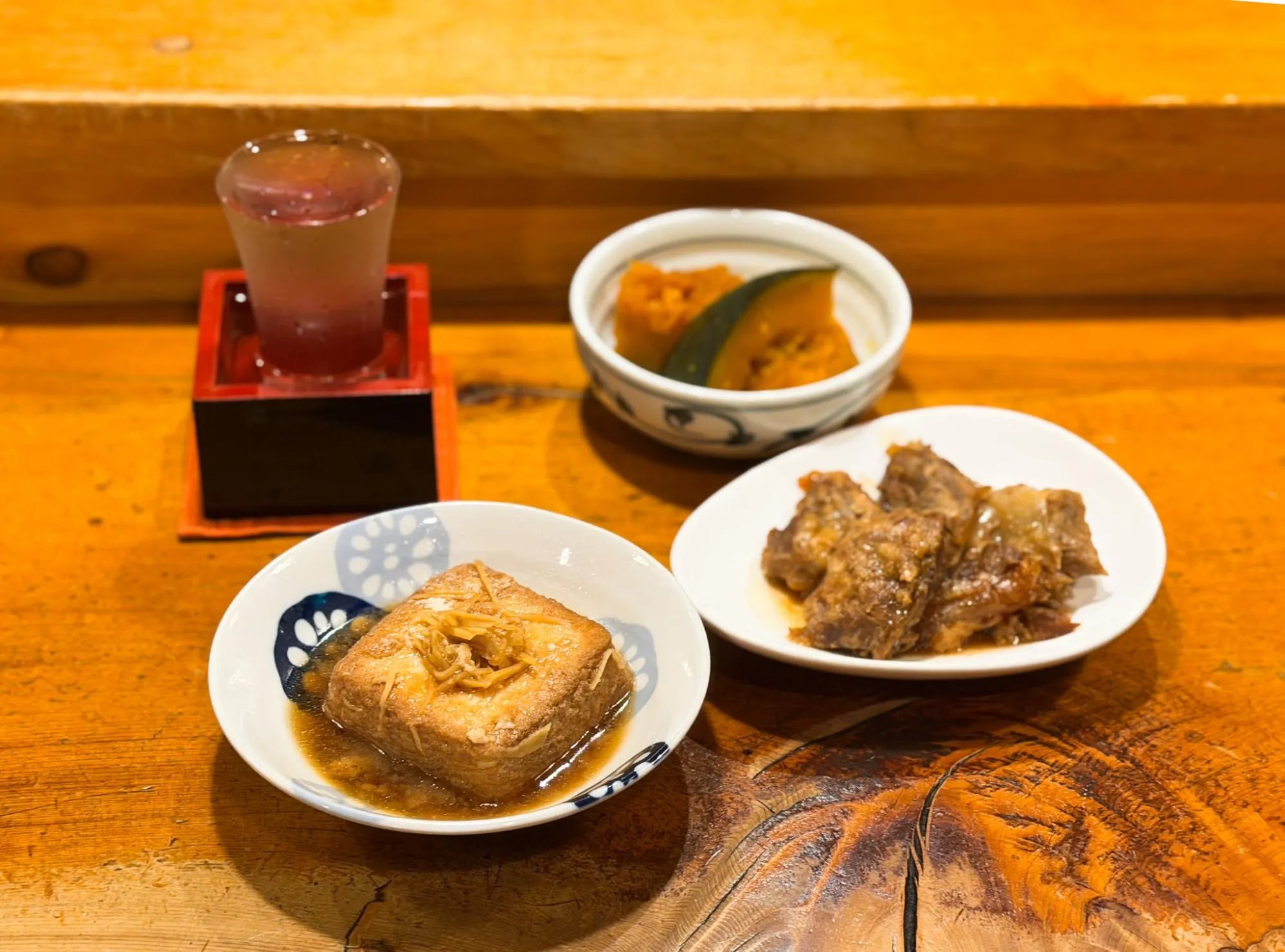 「山き」の厚揚げのしょうが煮やパイカ煮、カボチャの煮つけなど、お酒にも合う家庭料理たち。