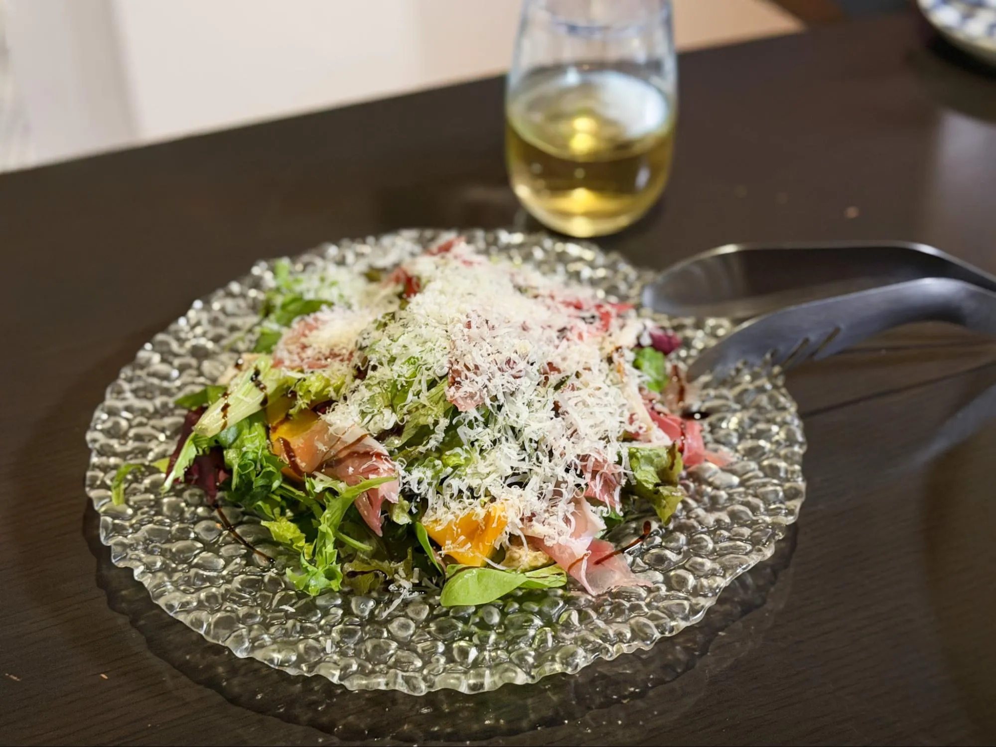 「暖だん」の、旬の果実をサラダ仕立てにした「旬果サラダ」1,100円。この日は柿が使われていました。バルサミコ酢を使った甘酸っぱいソースに柿の甘み、削ったチーズの塩気がよく合います。