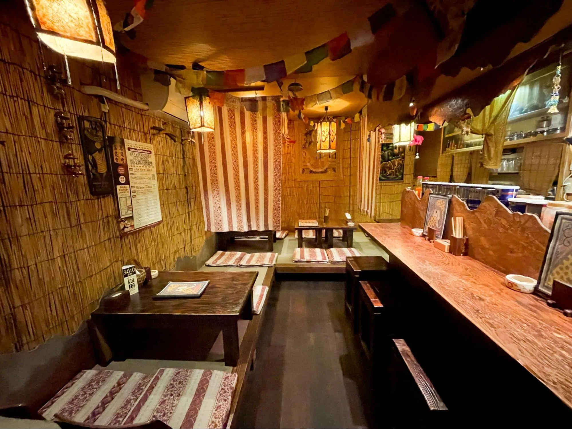 青森県八戸市のハーモニカ横丁にある「アジア酒場 チャクラ」の店内。ネパールでオーダーメイドした座布団カバーを敷いている